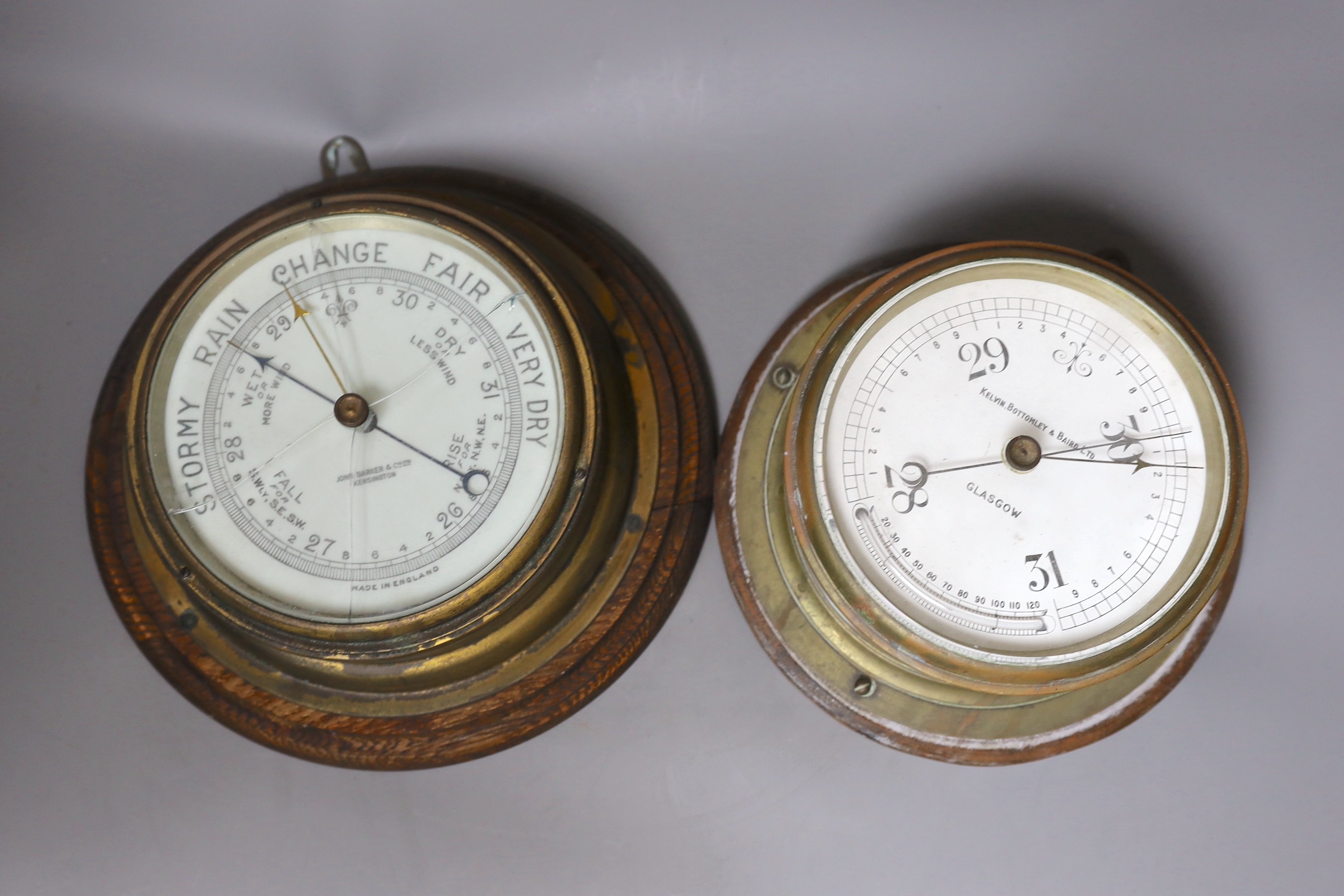 A John Barker & co brass bulkhead barometer and another by Kelvin Bottomly & Baird ltd., diameter 27.5 cm